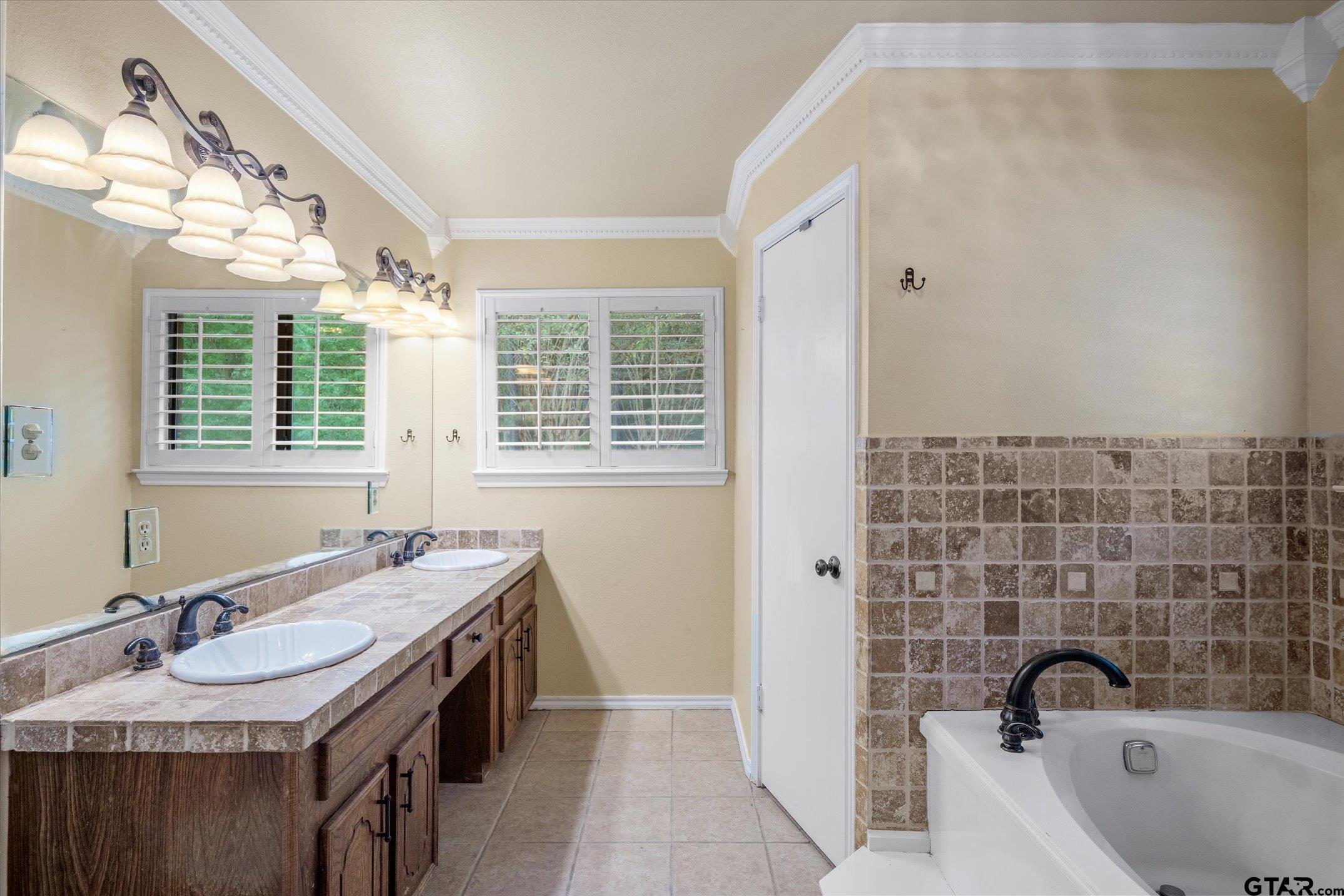 1936 Silver Maple Road Big Sandy, TX 75755 - Photo 19 of 48 a bathroom with a granite countertop sink a mirror a bathtub and window