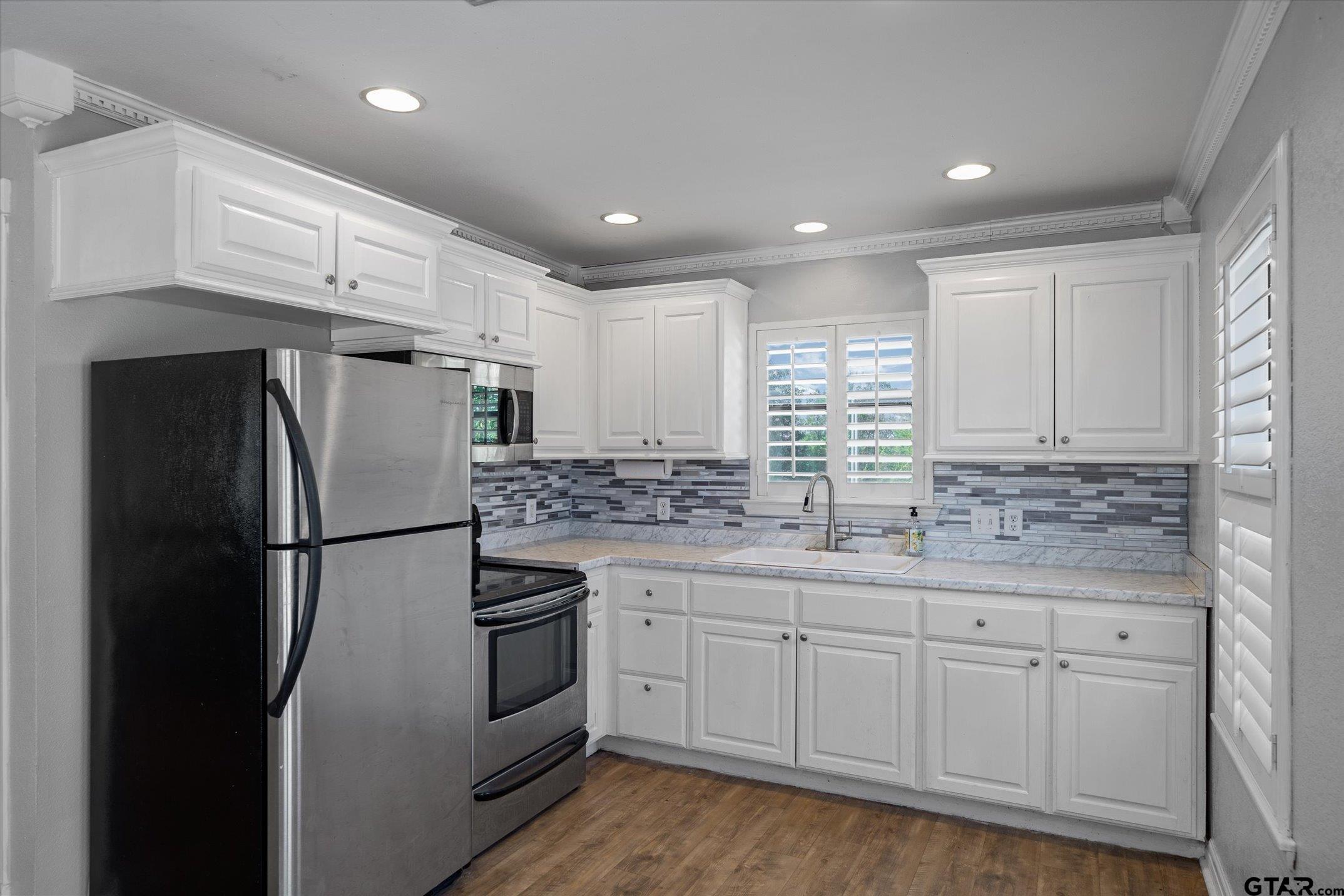 1936 Silver Maple Road Big Sandy, TX 75755 - Photo 26 of 48 a kitchen with white cabinets and white appliances