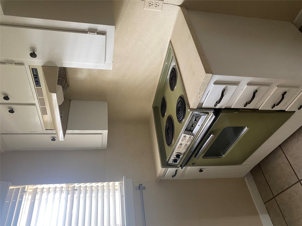 1601 Enfield Road, Unit 5 Austin, TX 78703 - Photo 8 of 20 Kitchen featuring electric stove, white cabinetry, light countertops, and under cabinet range hood