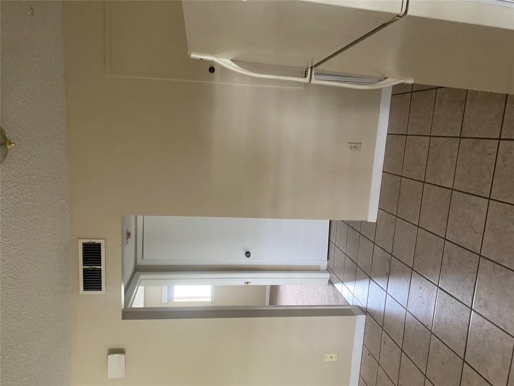 1601 Enfield Road, Unit 5 Austin, TX 78703 - Photo 9 of 20 Spare room featuring a textured ceiling and dark tile patterned floors