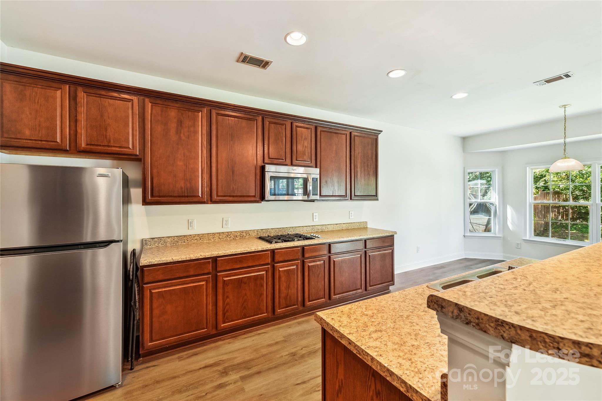 15614 Normans Landing Drive Charlotte, NC 28273 - Photo 7 of 21 a kitchen with stainless steel appliances granite countertop wooden cabinets a refrigerator and dishwasher