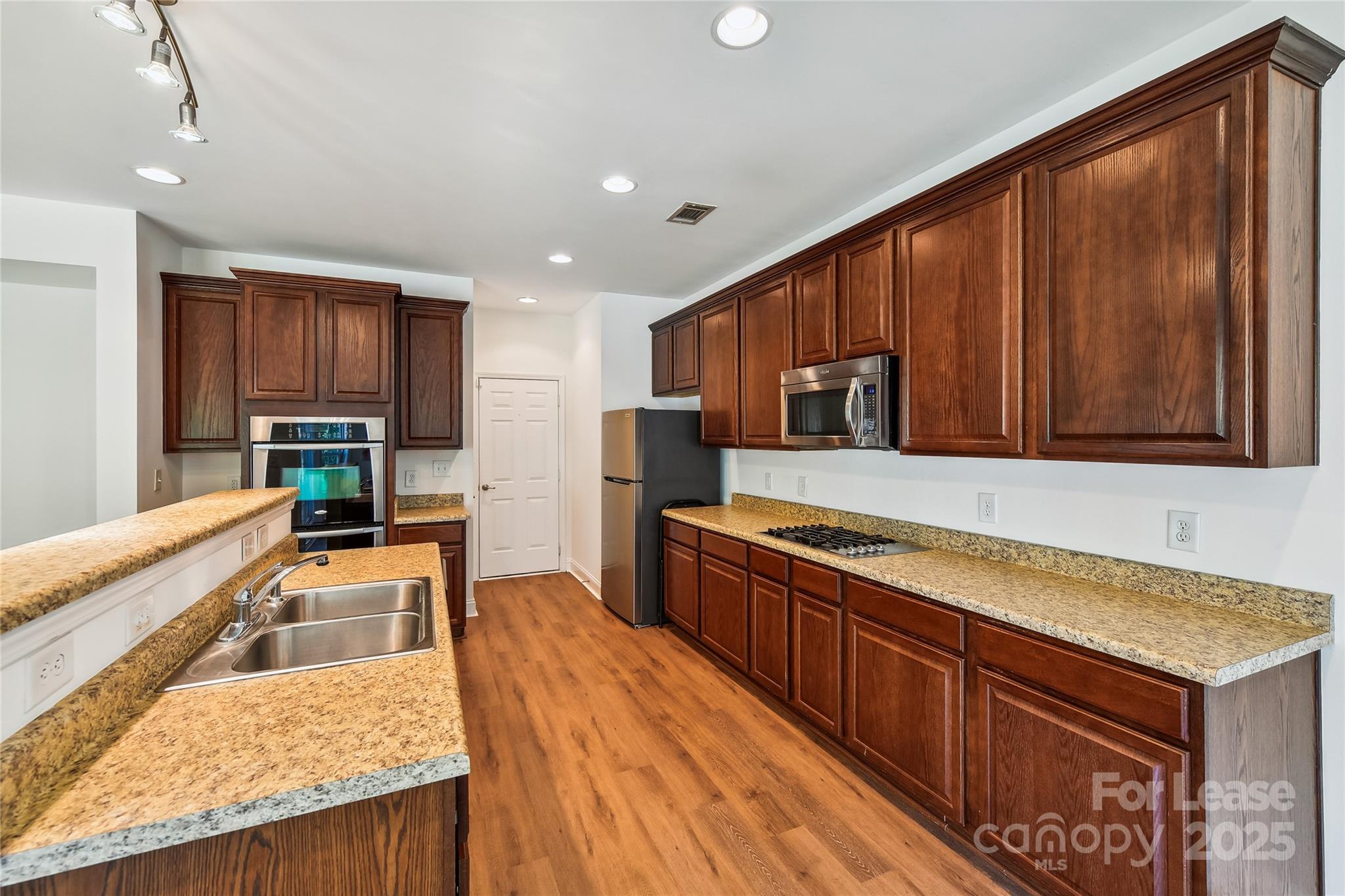 15614 Normans Landing Drive Charlotte, NC 28273 - Photo 9 of 21 a kitchen with stainless steel appliances granite countertop wooden cabinets a stove and a sink