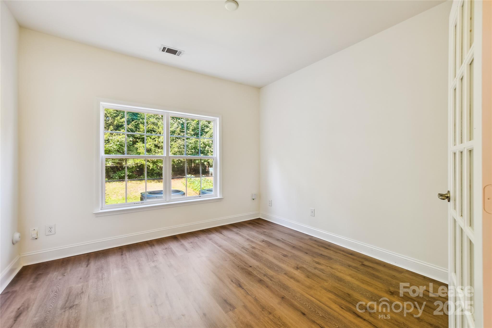 15614 Normans Landing Drive Charlotte, NC 28273 - Photo 10 of 21 an empty room with wooden floor and windows