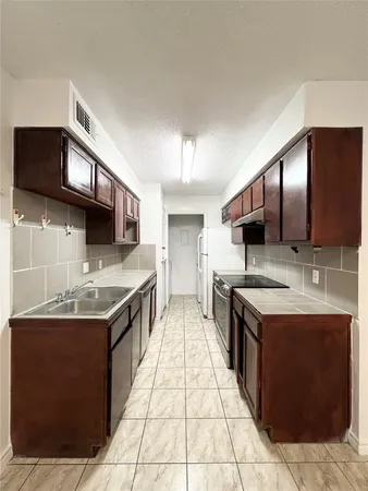 a kitchen with stainless steel appliances granite countertop a sink stove and cabinets