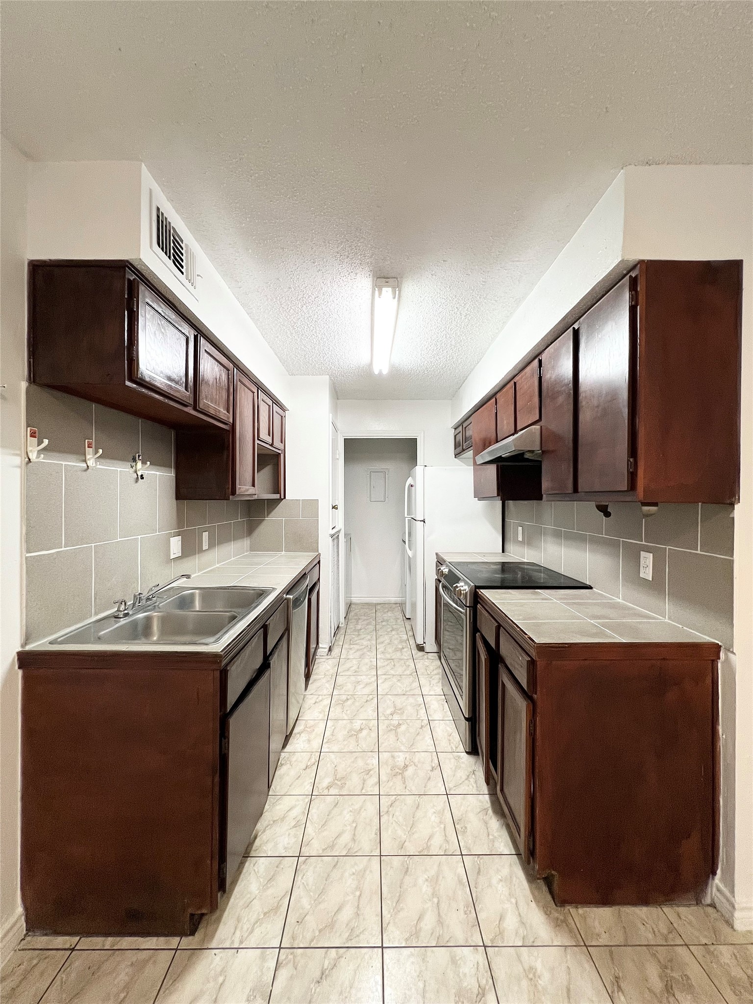 12710 Leader Street, Unit B Houston, TX 77072 - Photo 6 of 9 a kitchen with stainless steel appliances granite countertop a sink stove and cabinets