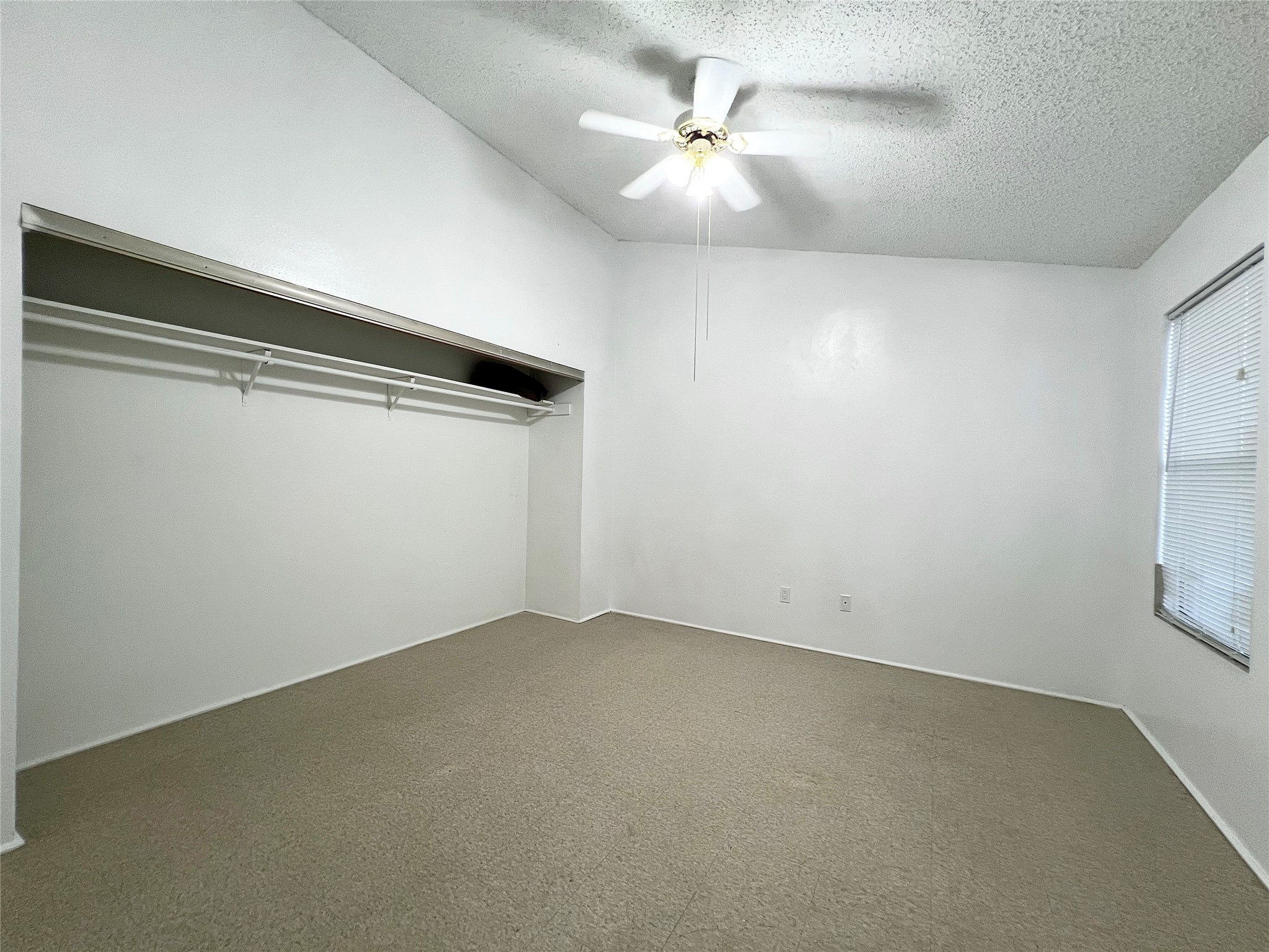 12710 Leader Street, Unit B Houston, TX 77072 - Photo 8 of 9 an empty room with a ceiling fan and window