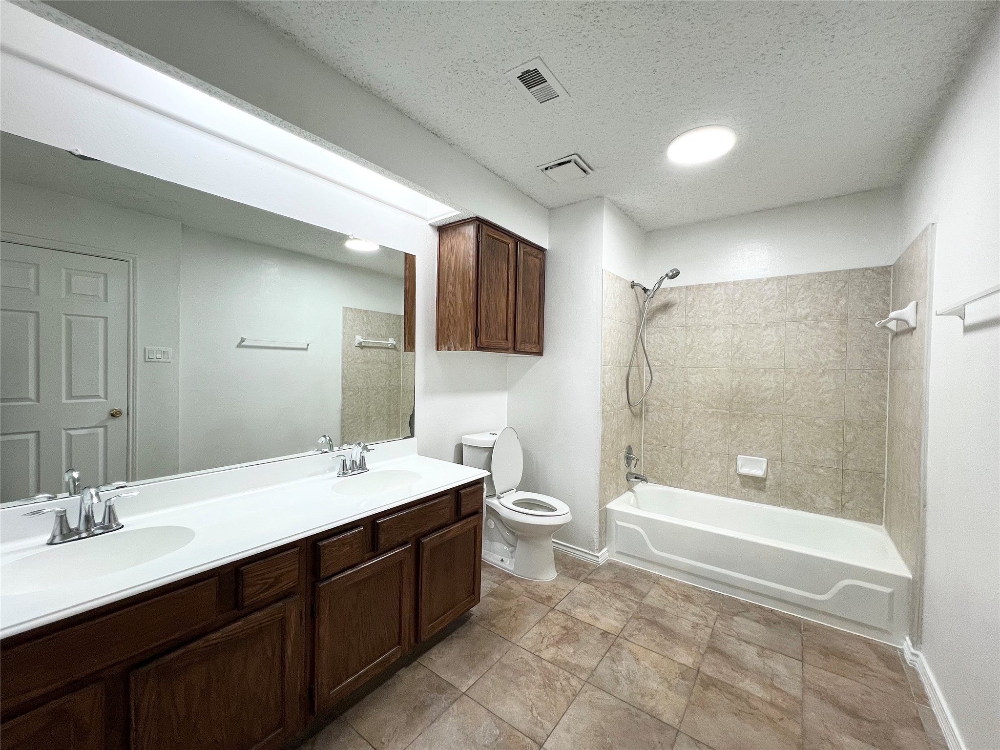 12710 Leader Street, Unit B Houston, TX 77072 - Photo 9 of 9 a bathroom with a double vanity sink a toilet a mirror and shower