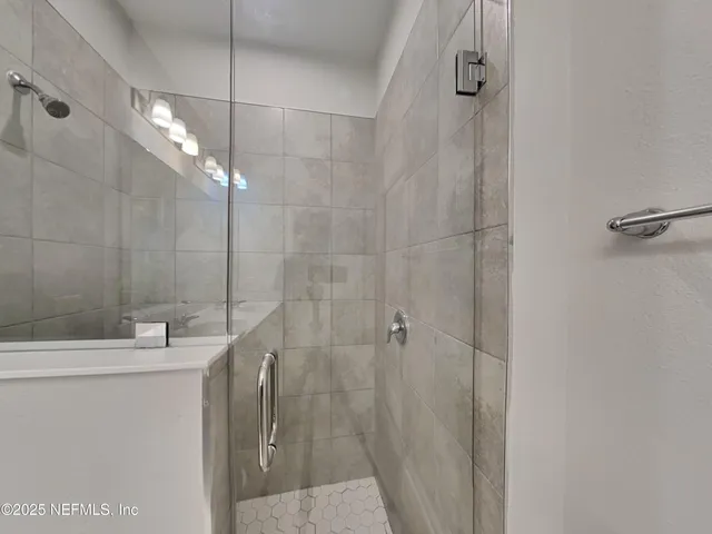a bathroom with a sink a mirror and shower