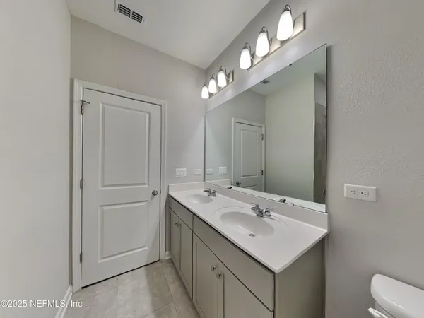a bathroom with a sink vanity and a mirror