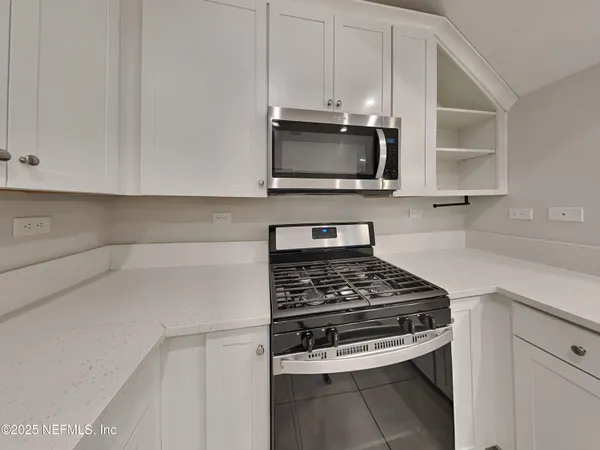 a kitchen with stainless steel appliances a stove a microwave and cabinets