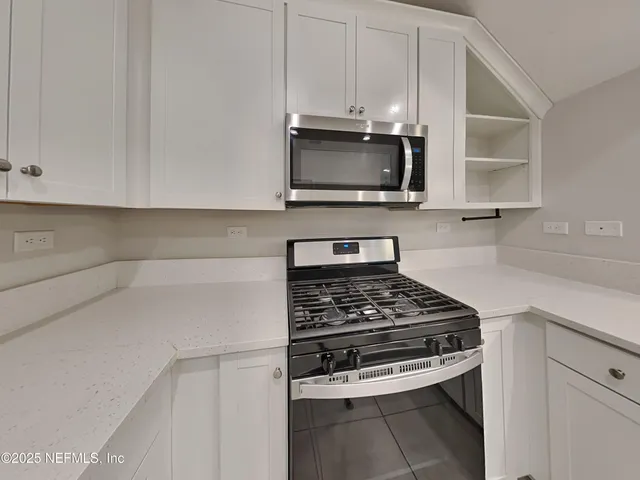 a kitchen with stainless steel appliances a stove a microwave and cabinets