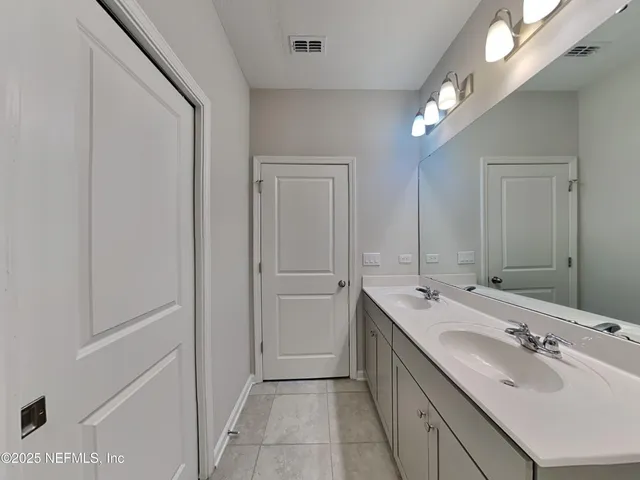 a bathroom with a double vanity sink and mirror