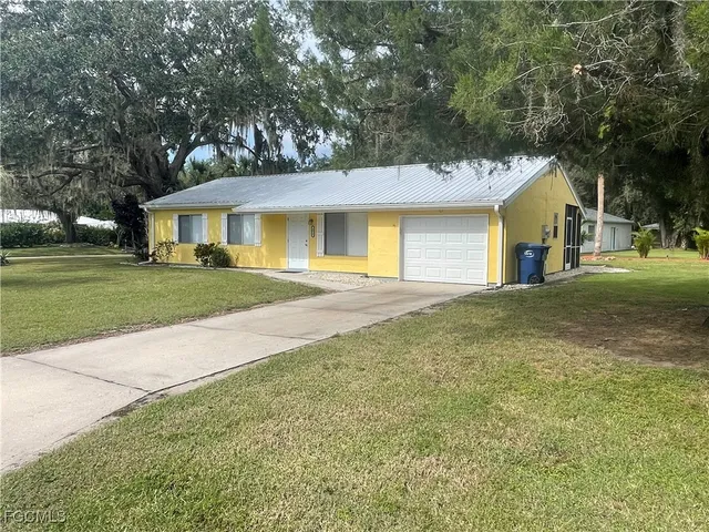 a front view of a house with a yard and trees