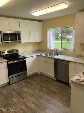 a kitchen with stainless steel appliances granite countertop a stove a sink and a microwave