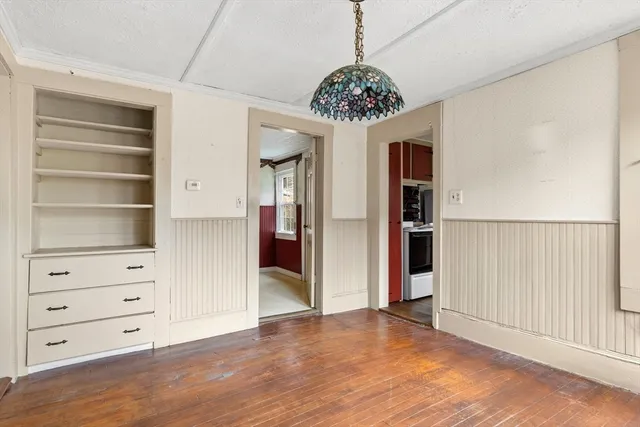 wooden floor in an empty room with a chandelier