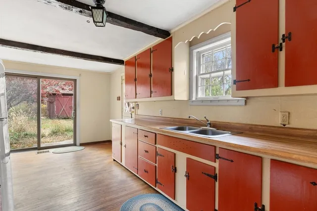 a kitchen with stainless steel appliances granite countertop a sink a stove cabinets and wooden floor