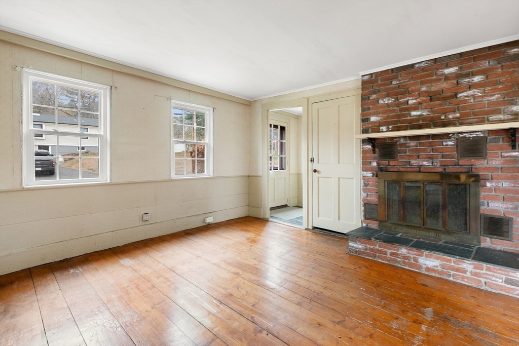 359 Kenoza Street Haverhill, MA 01830 - Photo 8 of 37 an empty room with wooden floor and fireplace