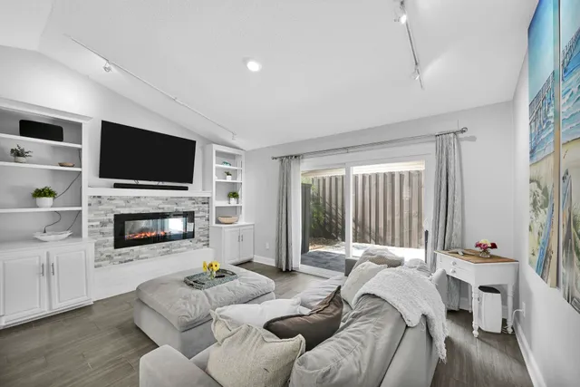 a living room with furniture a flat screen tv and a fireplace