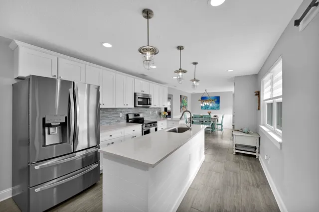 a kitchen with stainless steel appliances a sink a stove top oven a counter space and cabinets