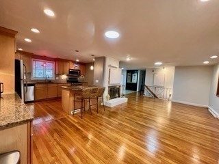 27 Sunset Drive Randolph, MA 02368 - Photo 11 of 37 a view of a kitchen with kitchen island a counter top space a sink appliances and cabinets