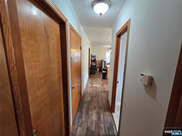a view of hallway with a door and wooden floor