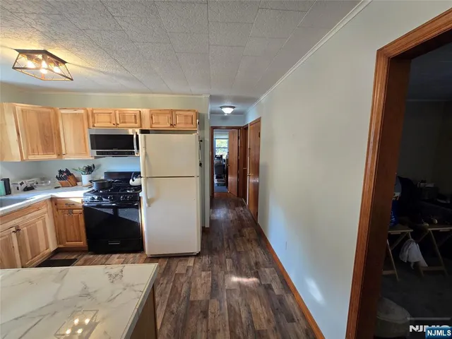a kitchen with a refrigerator and a stove top oven