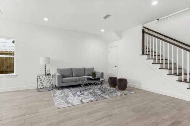 a living room with furniture and a wooden floor