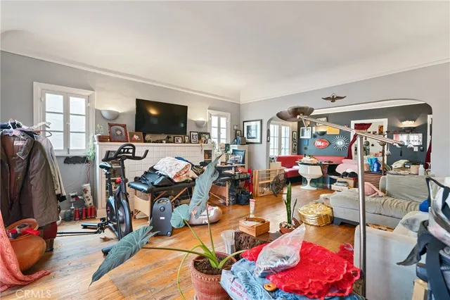 a bedroom with a bed chandelier and a flat tv screen