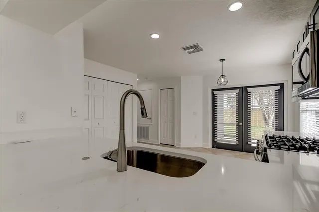 a kitchen with stainless steel appliances granite countertop a stove and a microwave