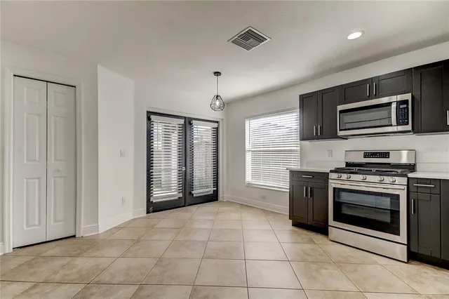 a kitchen with stainless steel appliances granite countertop a stove top oven microwave and cabinets