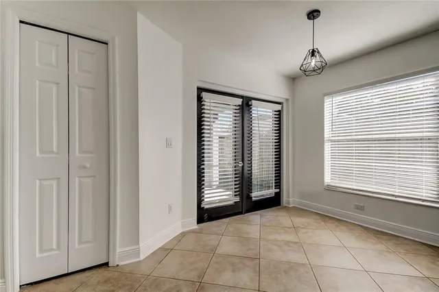 a view of an empty room with a window and a kitchen