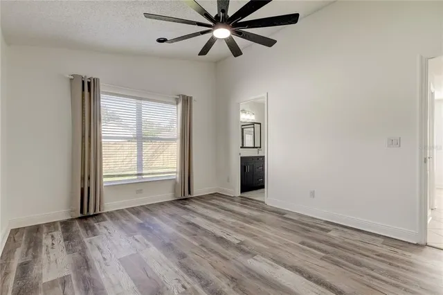 a view of a room with a ceiling fan and wooden floor