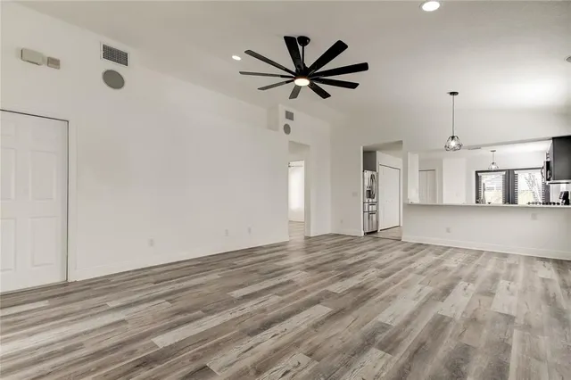 a view of a livingroom with a ceiling fan a ceiling fan and kitchen view