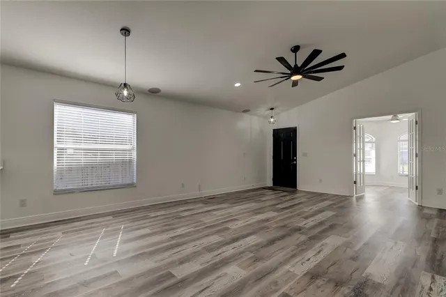 a living room with stainless steel appliances kitchen island granite countertop a refrigerator a stove top oven a sink and dishwasher