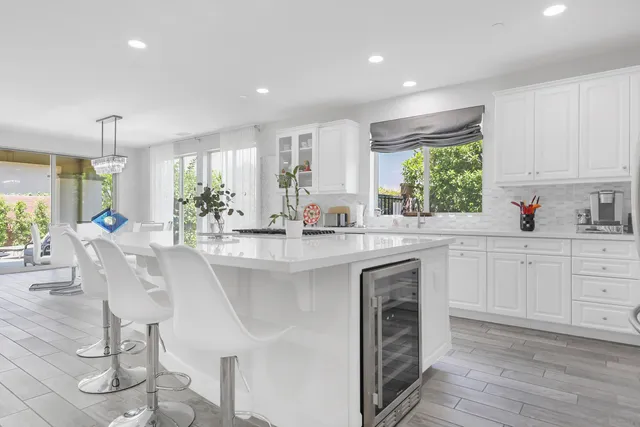 a kitchen with granite countertop white cabinets and white appliances with a large window