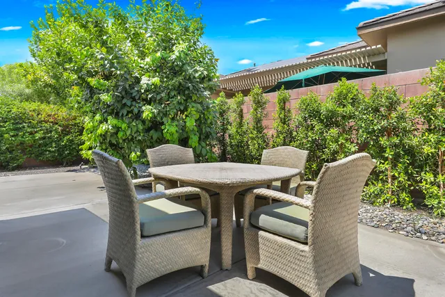 a view of a patio with couches table and chairs and potted plants