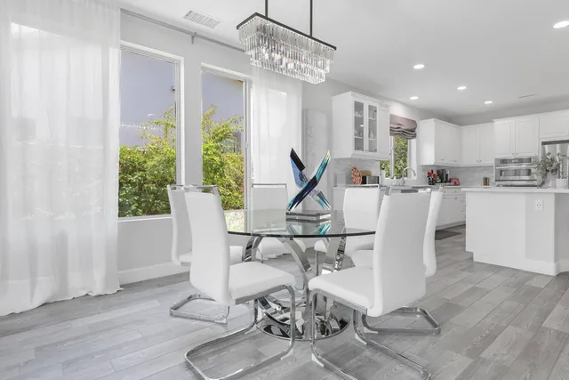 a view of a dining room with furniture a chandelier and wooden floor