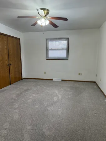 a view of a livingroom with a ceiling fan and window
