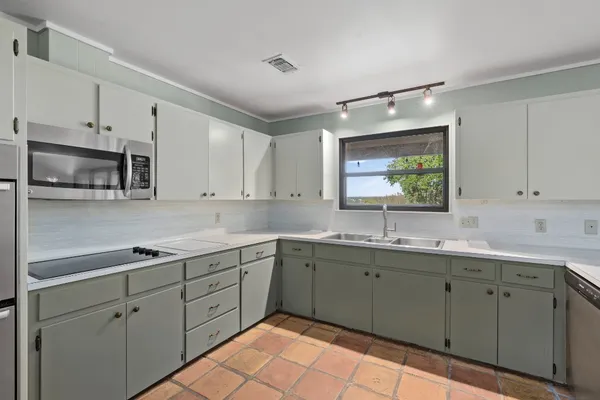 a view of kitchen with stainless steel appliances cabinets