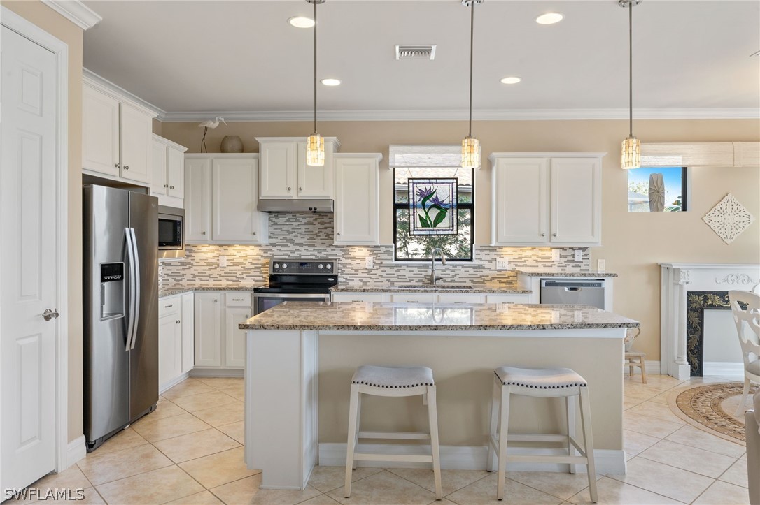 10845 Dennington Road Fort Myers, FL 33913 - Photo 6 of 46 a kitchen with kitchen island granite countertop counter top space appliances and cabinets