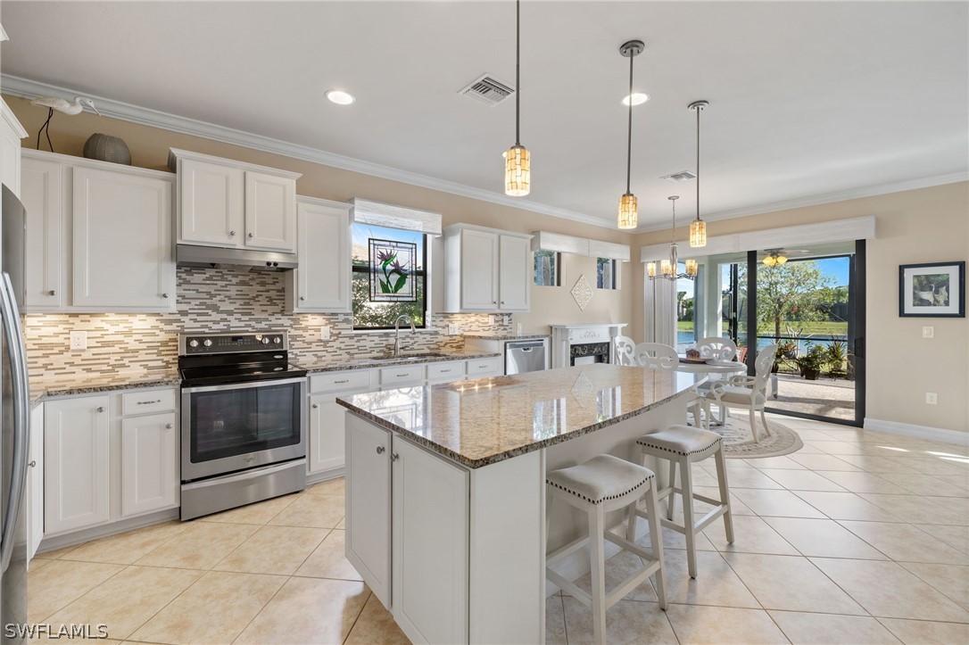 10845 Dennington Road Fort Myers, FL 33913 - Photo 7 of 46 a kitchen with stainless steel appliances granite countertop a stove a sink a oven a counter space and a center island