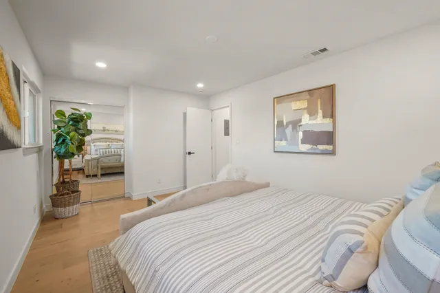 a bedroom with a bed and a painting on the wall