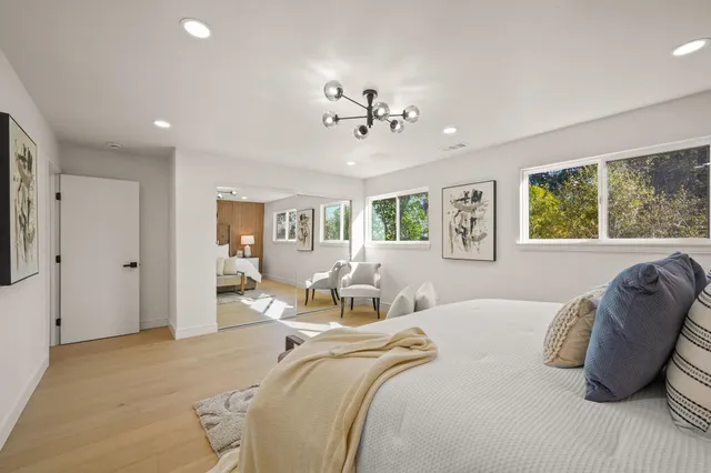 a bedroom with a large bed and a chandelier