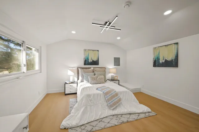 a bed sitting in a bedroom next to a window