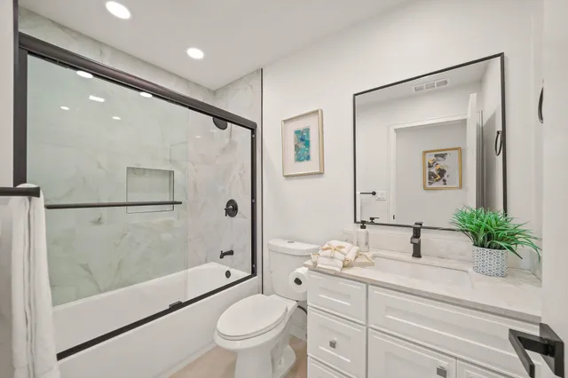 a spacious bathroom with a granite countertop sink toilet and shower