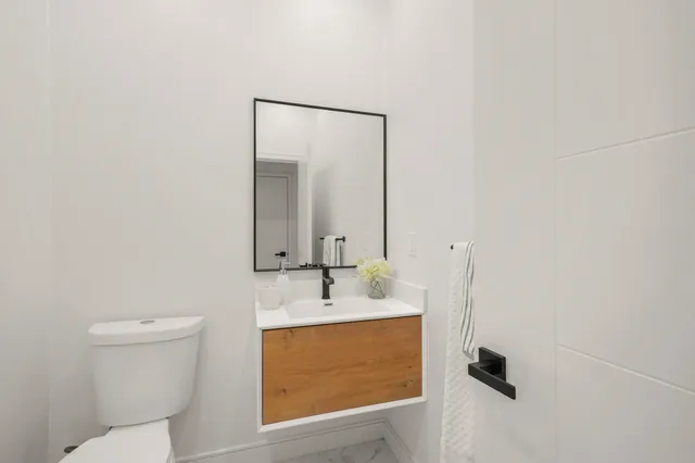 a bathroom with a sink a toilet and mirror