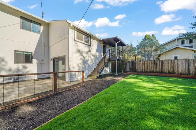 a view of a house with backyard and a tree