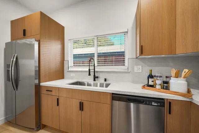 a kitchen with stainless steel appliances granite countertop a sink refrigerator and cabinets