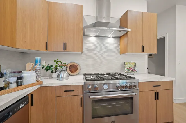 a kitchen with a stove and a white cabinets
