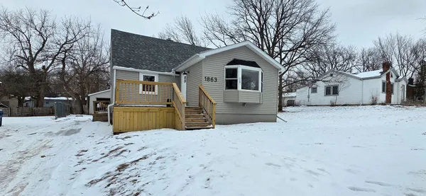 a view of a house with a yard covered in snow